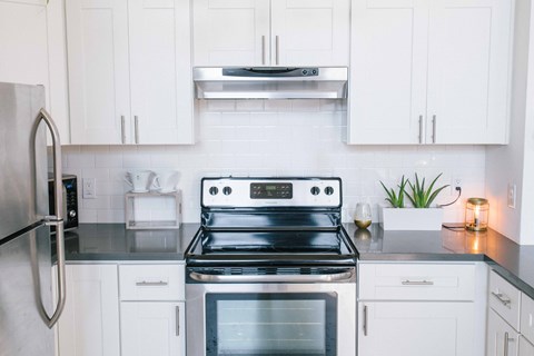 a white kitchen with stainless steel appliances and white cabinets