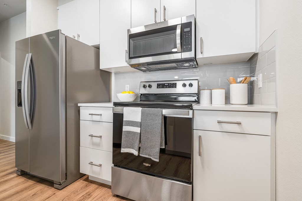a kitchen with white cabinets and stainless steel appliances
