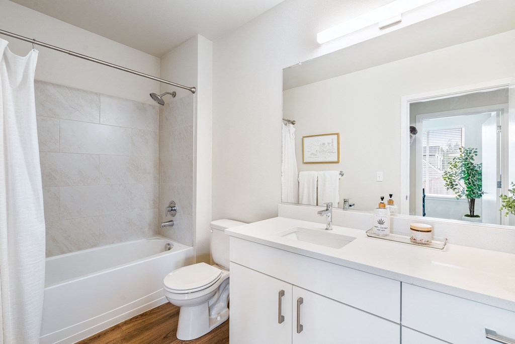 a bathroom with a white sink and toilet and a white bathtub with a shower curtain and