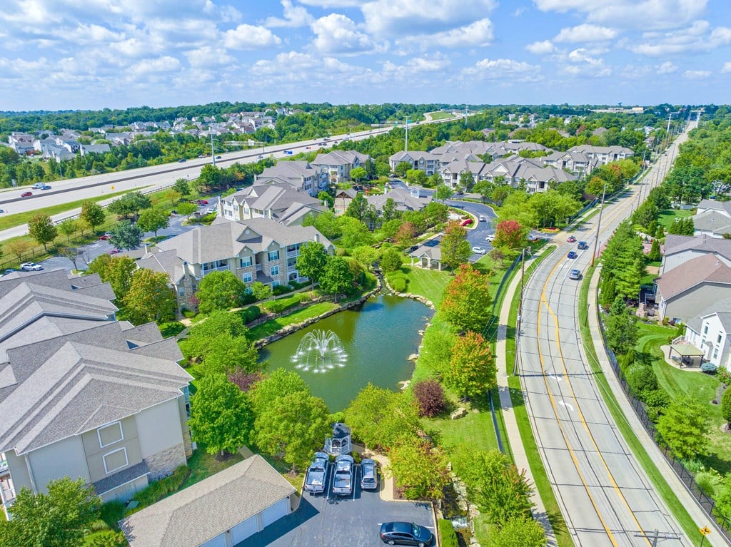 an aerial view of a neighborhood with a lake and fountain