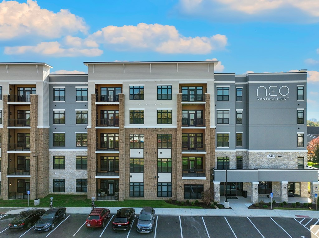 a large apartment building with cars parked in a parking lot