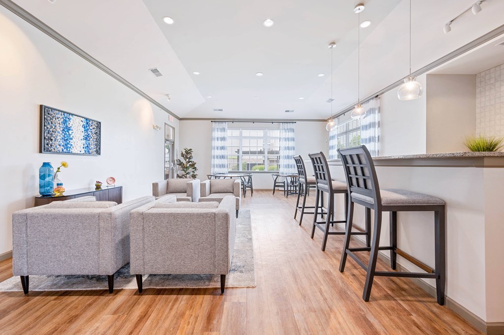 a seating area with couches chairs and a bar