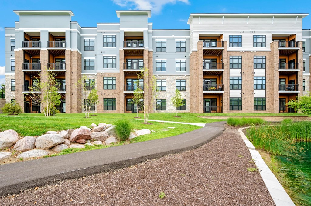 A modern apartment complex with a walkway in front.