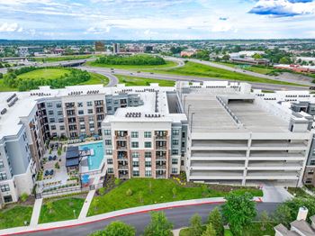 A large apartment complex with a pool and a parking garage.