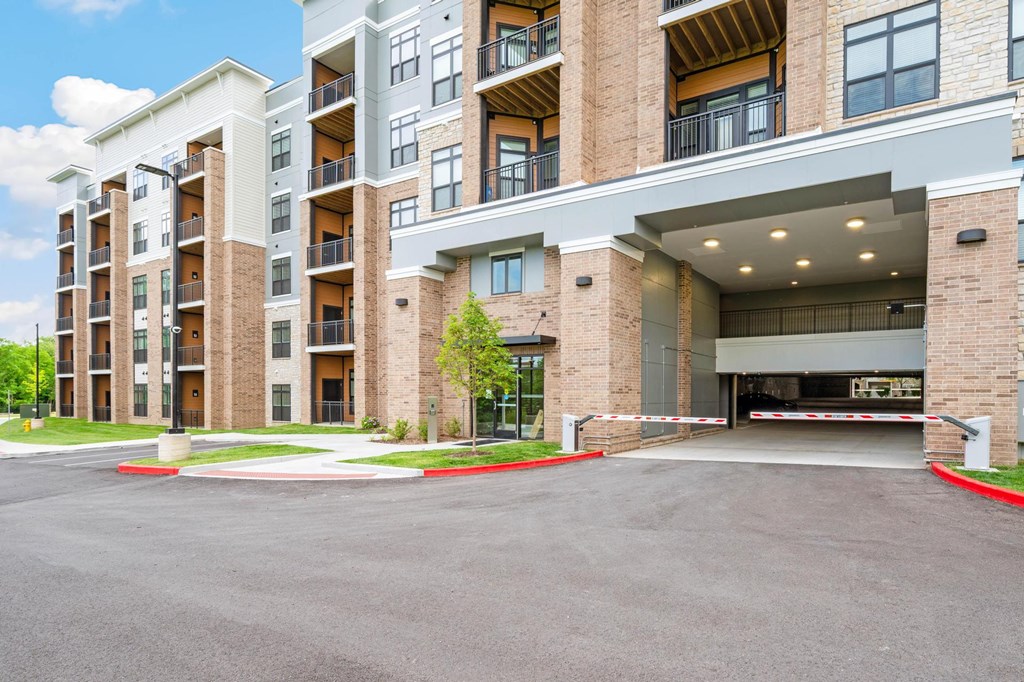A large apartment complex with a parking lot in front.