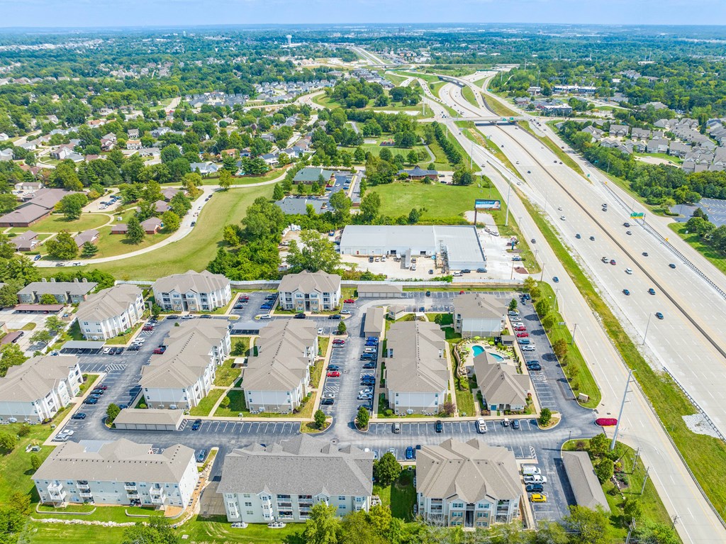 an aerial view of a neighborhood of houses with cars parked on the side of the road