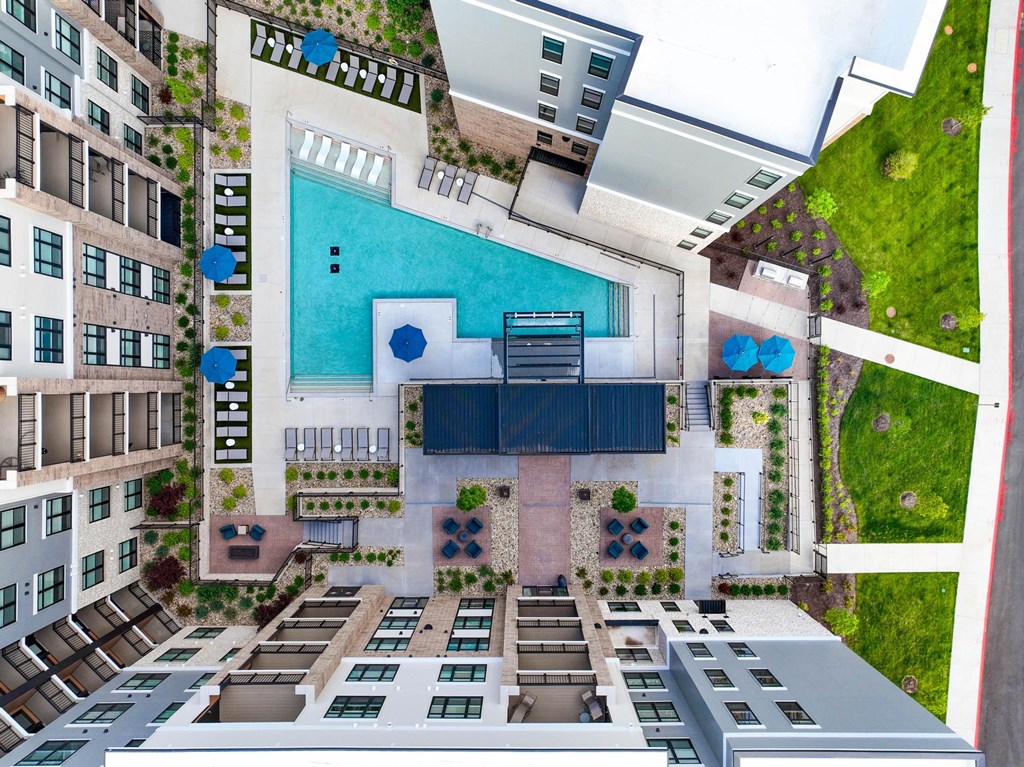 A swimming pool is surrounded by apartment buildings.