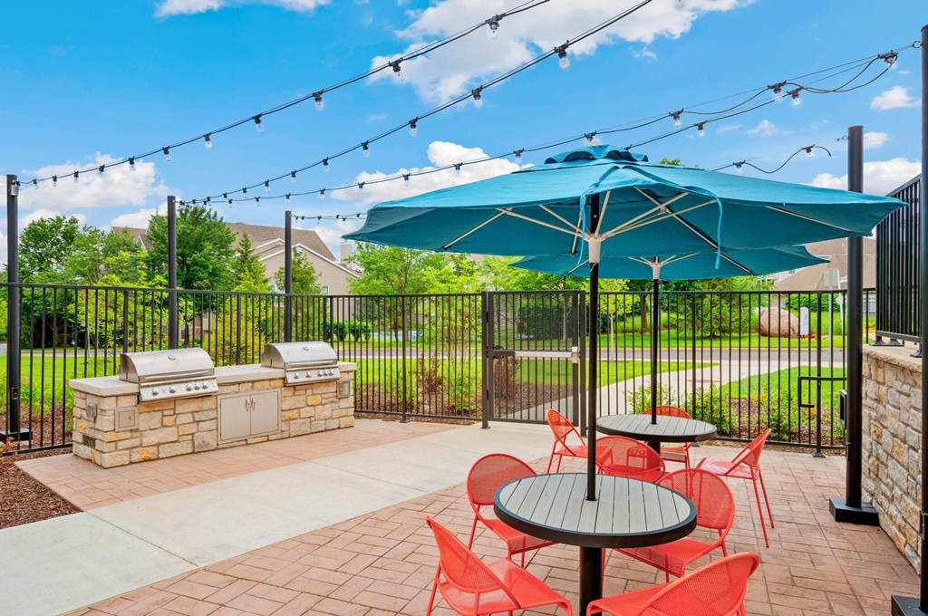 A patio with a table and chairs under a green umbrella.