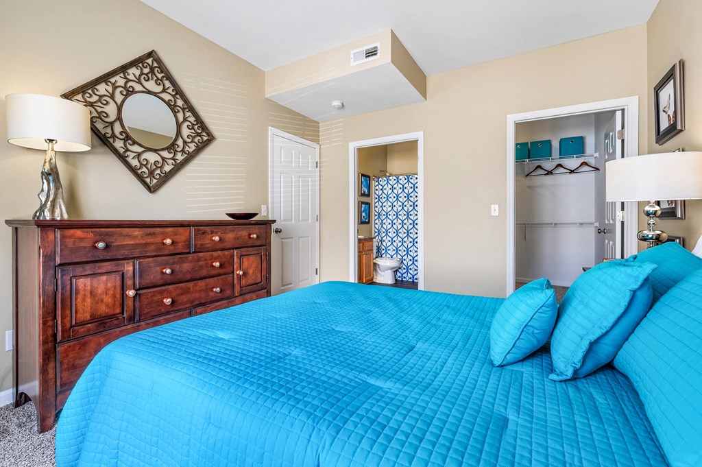 a bedroom with a blue bed and a dresser