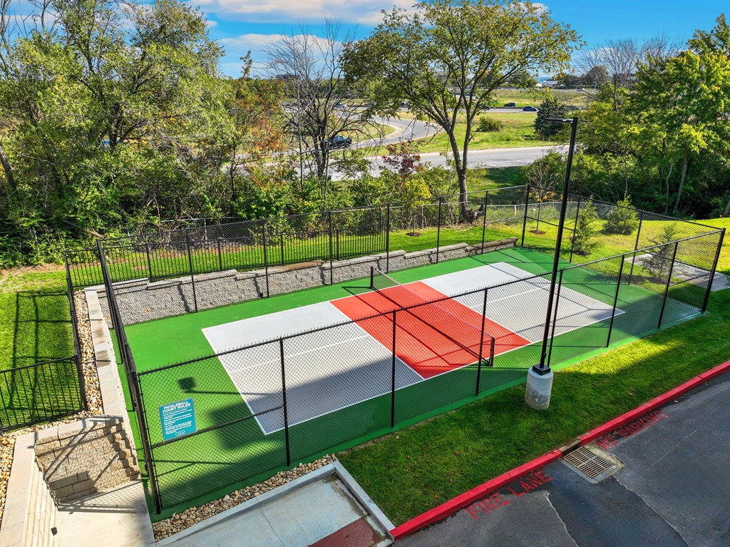 a tennis court with a fence around it in a park