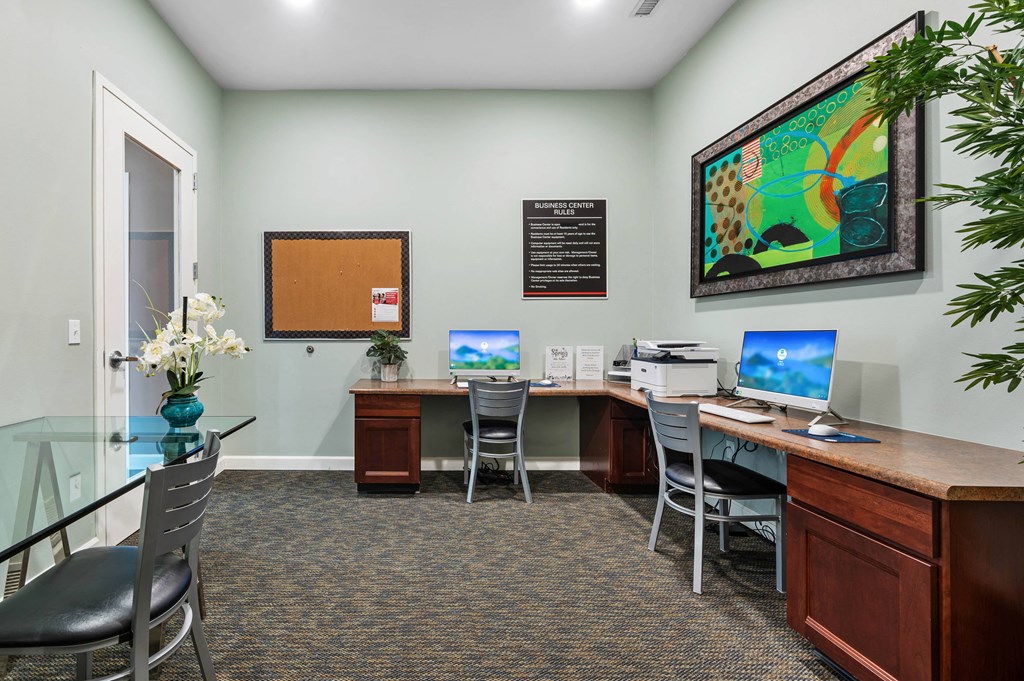 a office with two computers and a desk with chairs