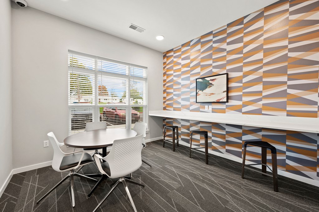a meeting room with a table and chairs and a colorful wall