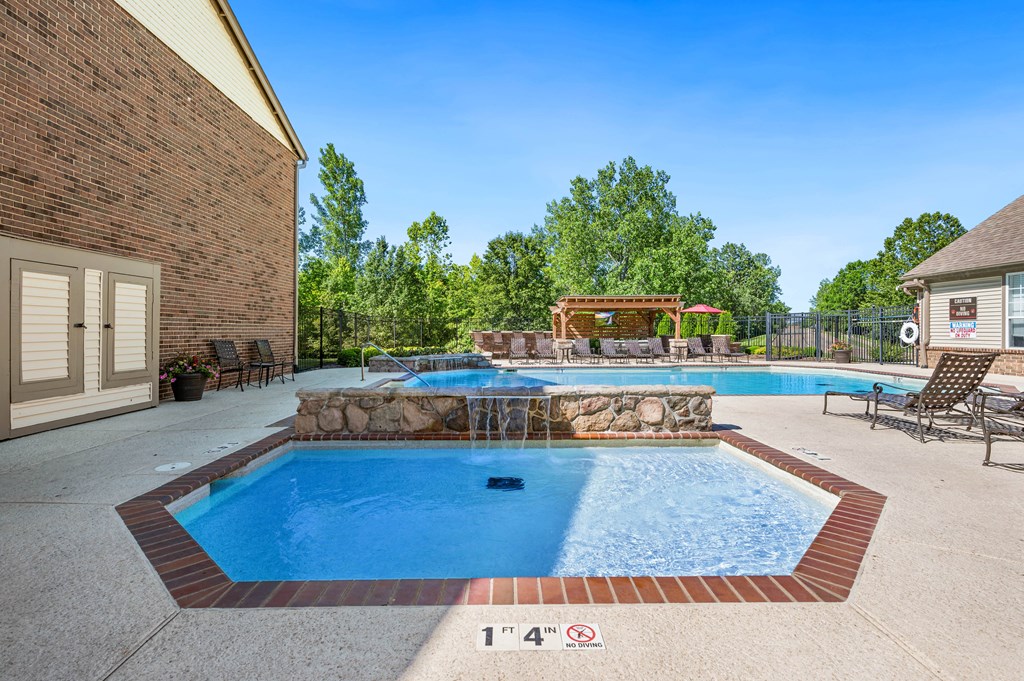 our resort style swimming pool is next to our house with a spa and a patio
