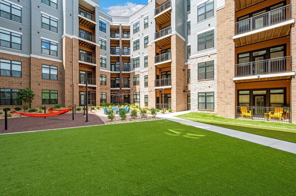 A modern apartment complex with a green lawn in the foreground.