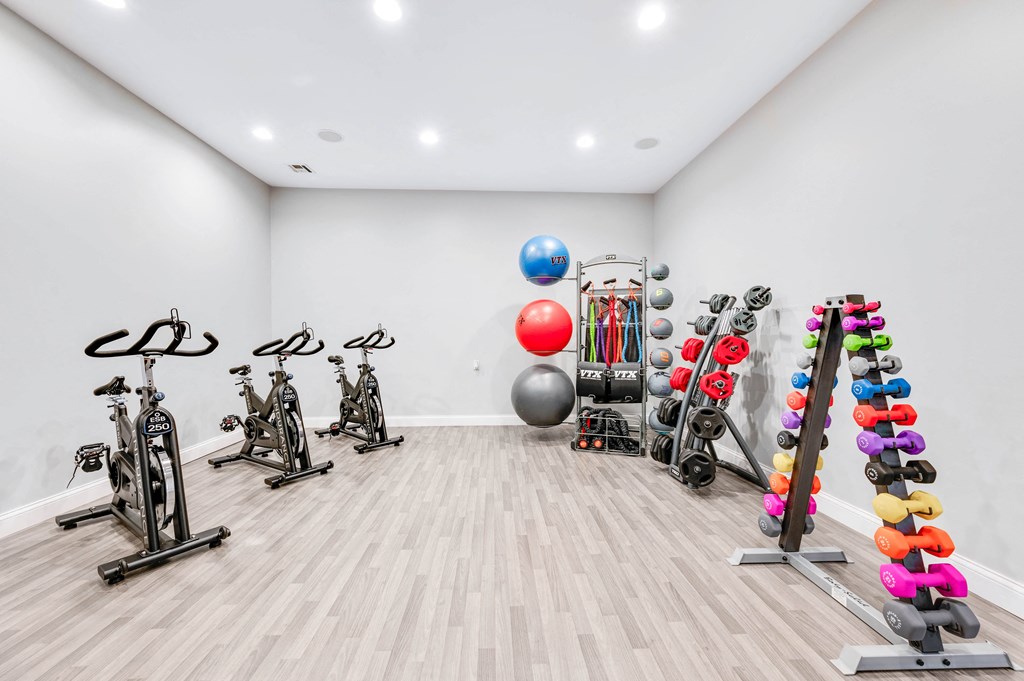a spacious fitness room with a variety of exercise equipment