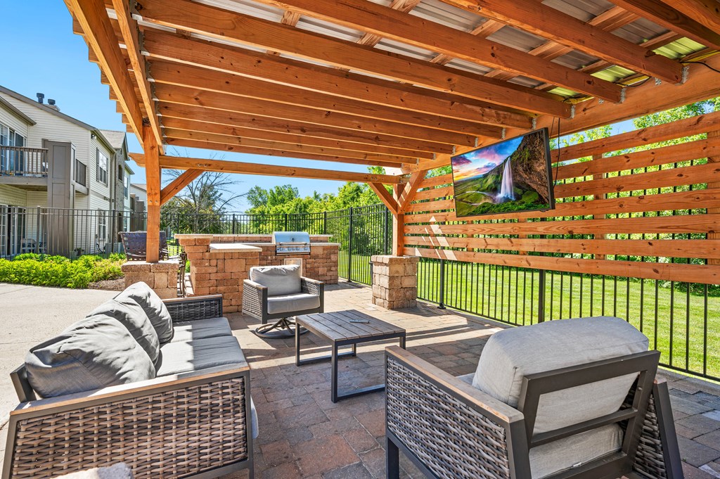 a covered patio with furniture and a grill