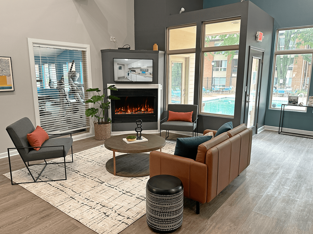 a living room with a fireplace and chairs and a table