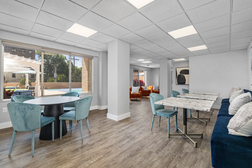 a common room with a couch table and chairs and a large window