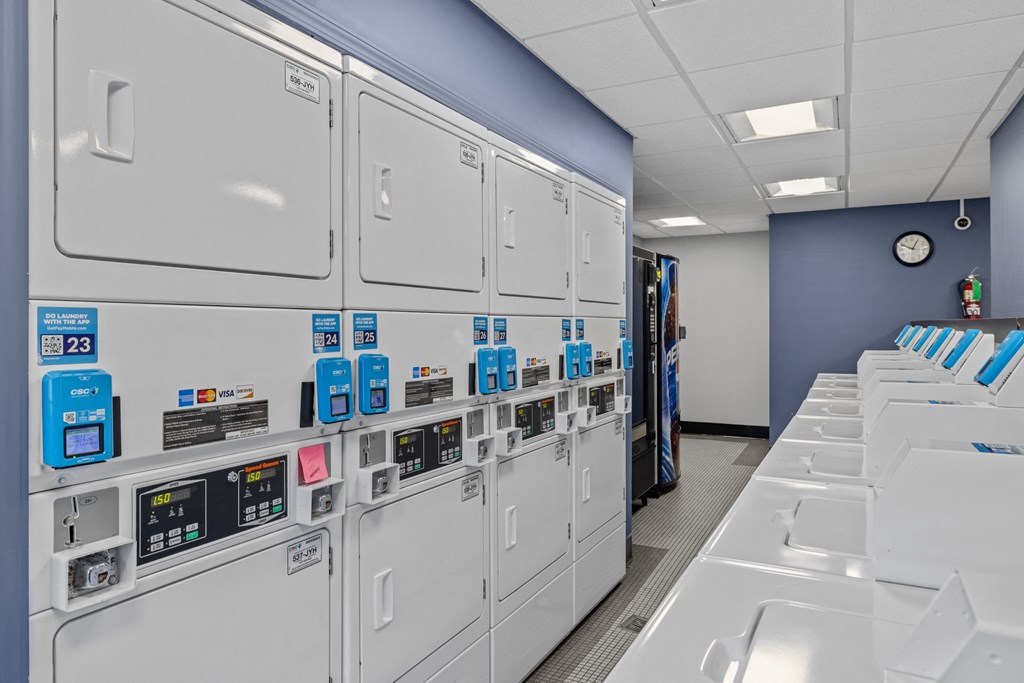 a row of gray lockers in a room with a clock on the wall