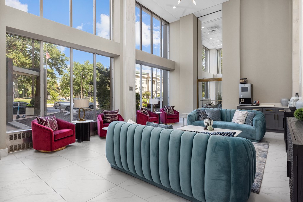 a living room filled with furniture and large windows