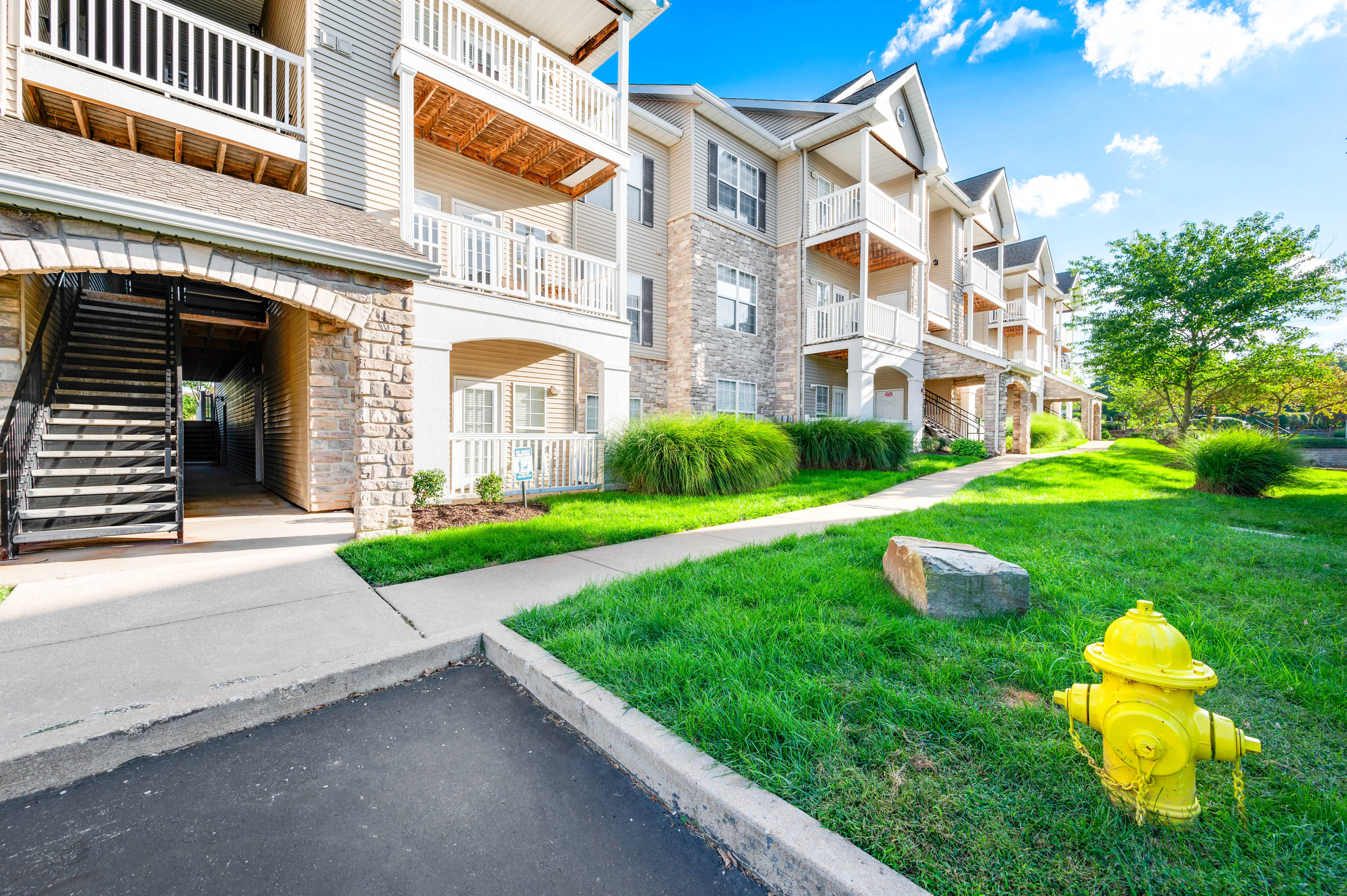 a yellow fire hydrant in front of an apartment building
