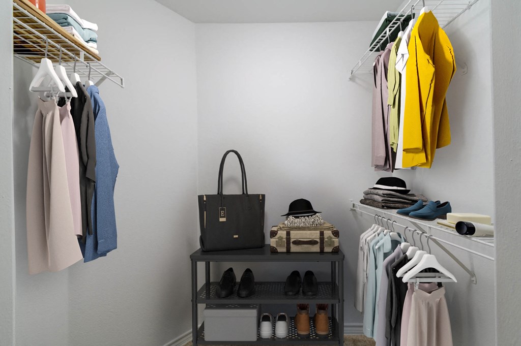 a closet with a rack of clothes and a bag
