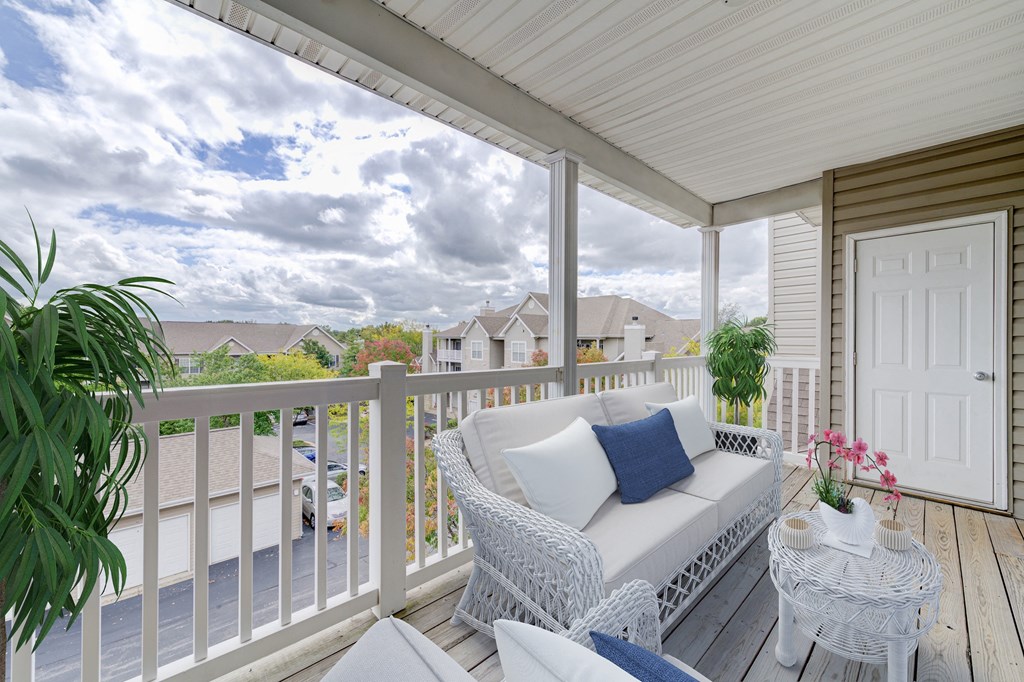 a white porch with two white chairs and a white door