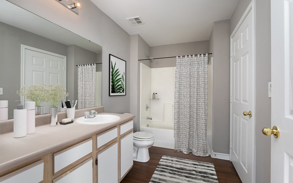 a bathroom with a shower and a sink and a toilet