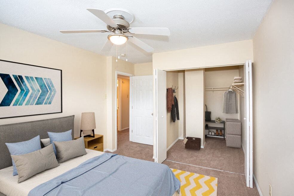 a bedroom with a bed and a ceiling fan