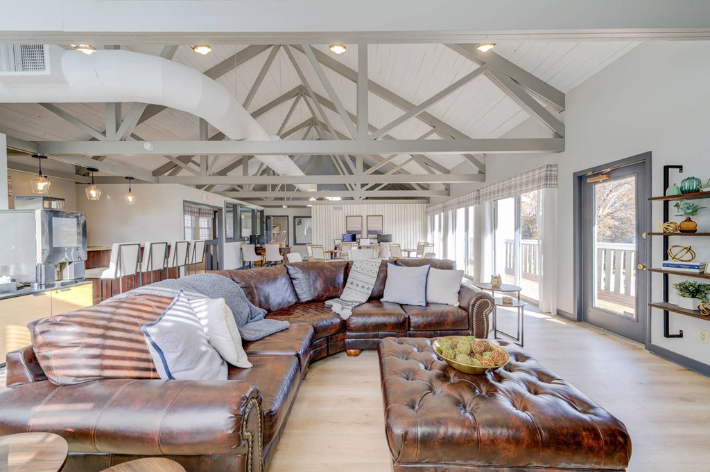 a large living room with leather couches and a table