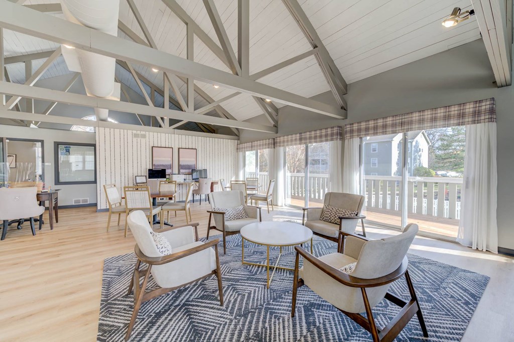 a living room with chairs and tables and a balcony