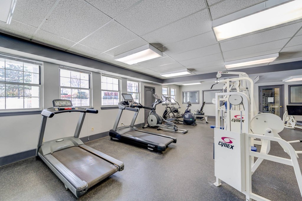 a gym with various exercise equipment and windows