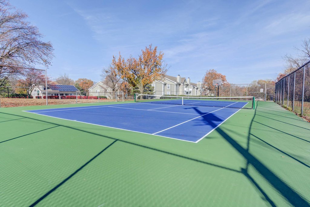 the tennis court is wheelchair accessible and has a net on it
