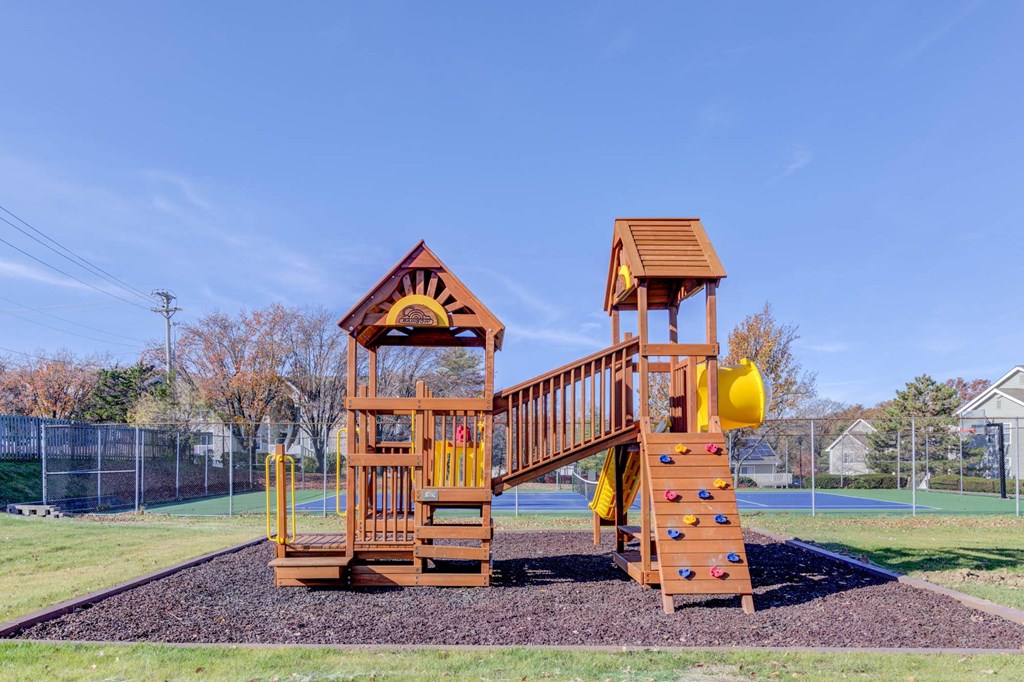 a wooden playset with a slide in a park