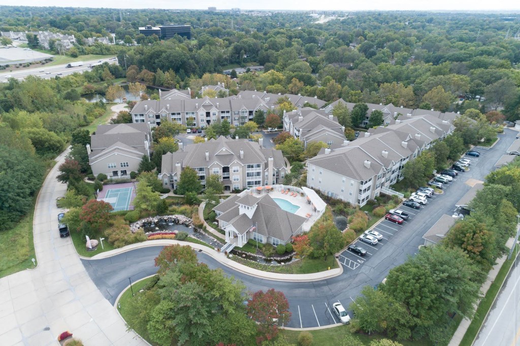 an aerial view of a large complex of houses with cars parked on the side of the road