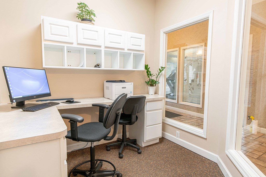 a home office with a computer and a window