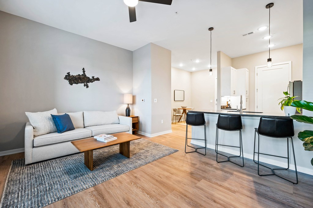 a living room with a couch and a kitchen with a bar