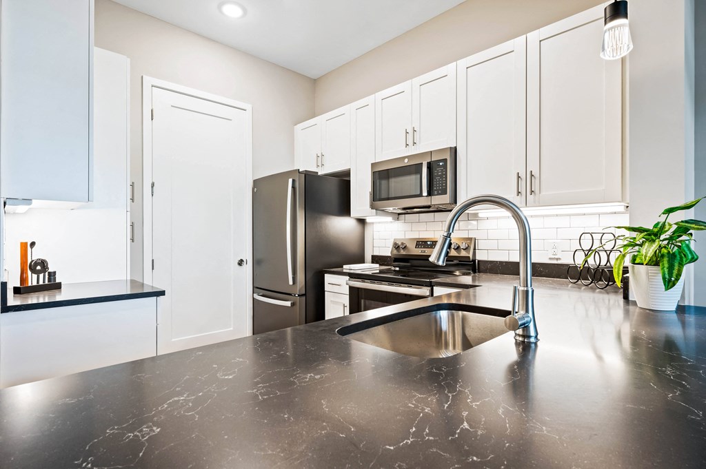 a modern kitchen with stainless steel appliances and black counter tops