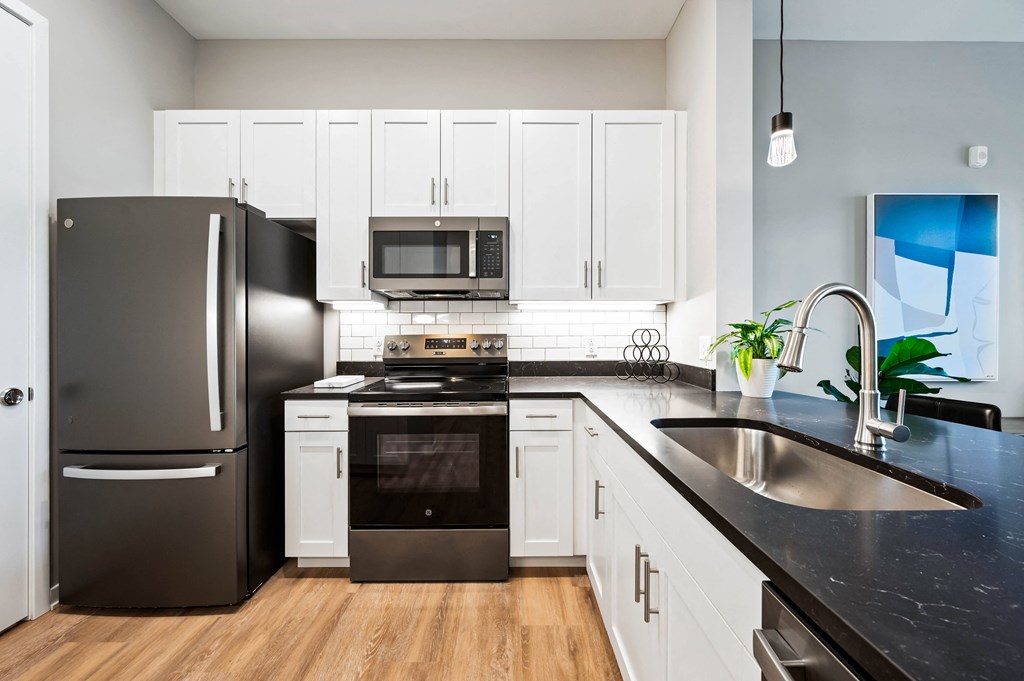 a kitchen with stainless steel appliances and black counter tops