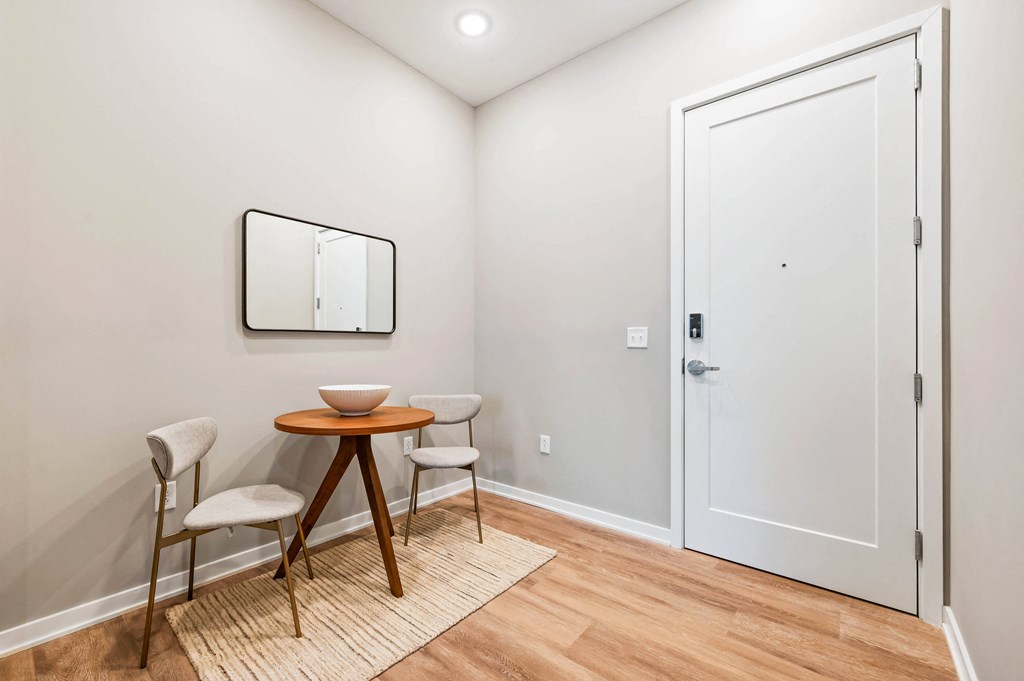 a small dining room with two chairs and a table and a door