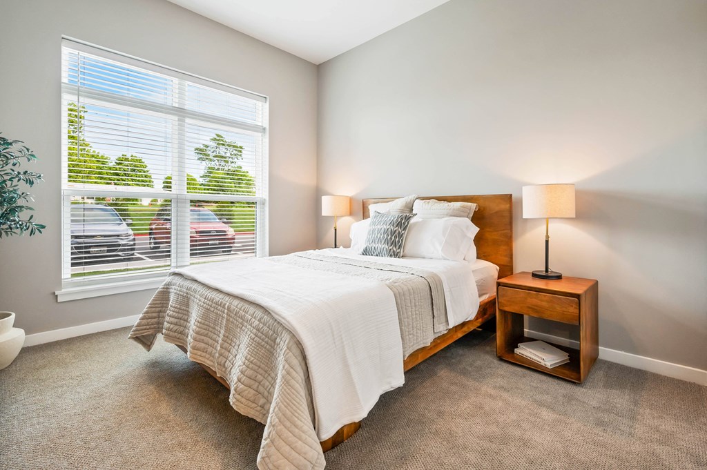 a bedroom with a large window and a bed