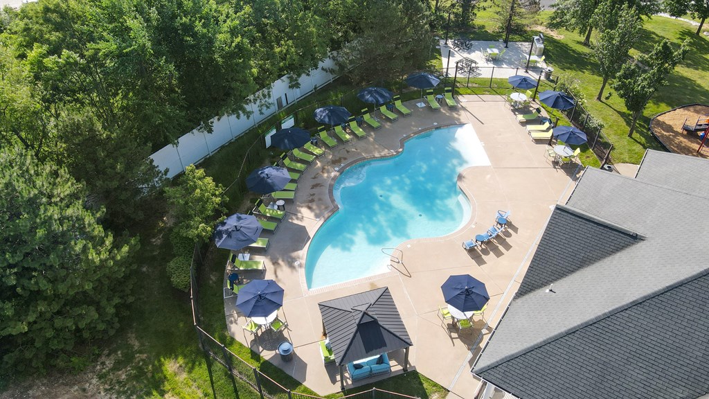 a pool is shown in a backyard with umbrellas