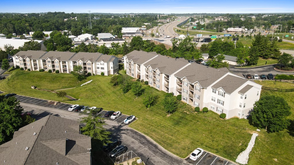 an aerial view of an apartment complex with cars parked in front