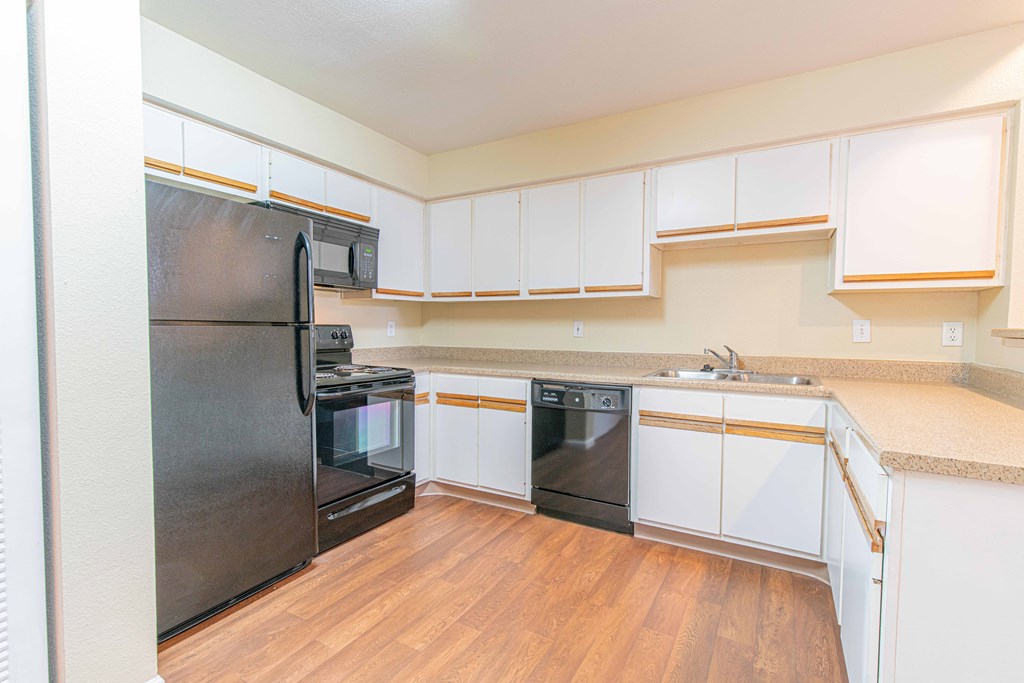 a kitchen with white cabinets and black appliances