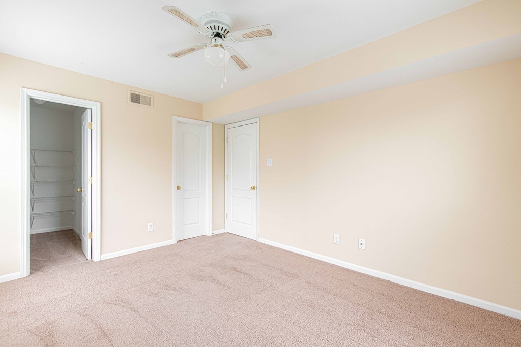 a bedroom with a ceiling fan and closet