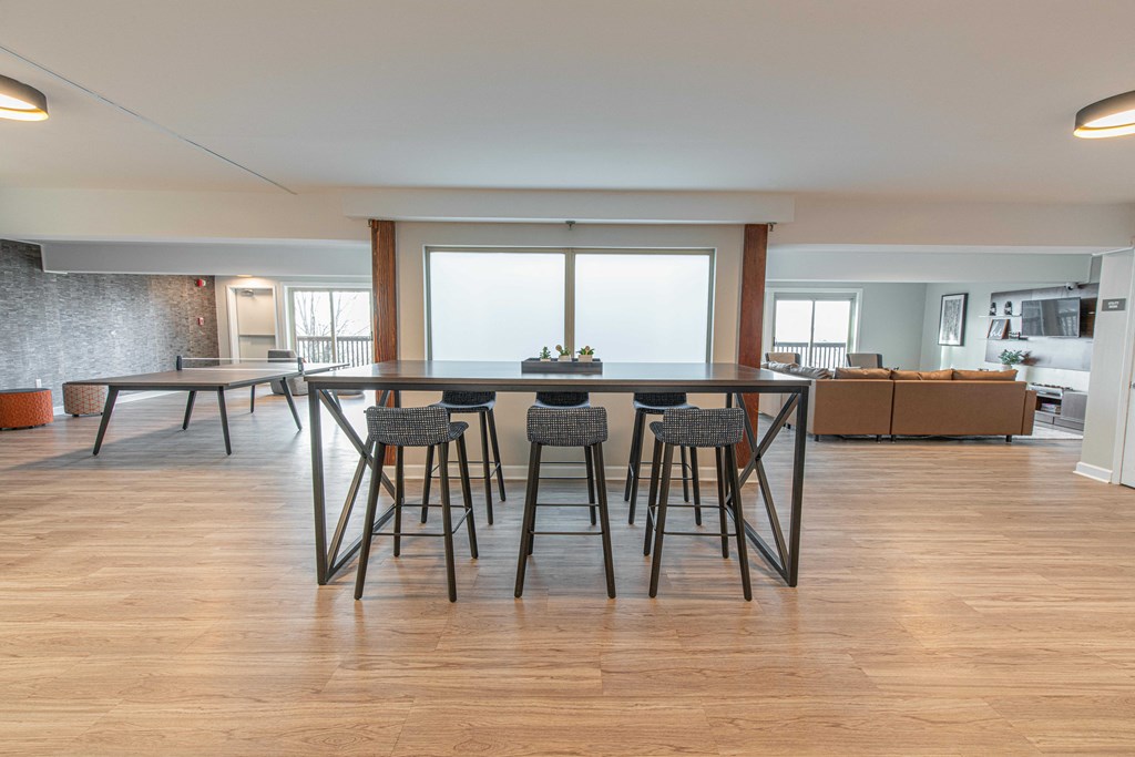 a dining area with bar stools and a table with chairs in a living room
