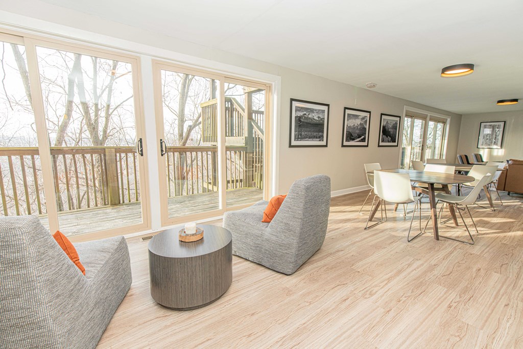 a living room with couches and a table and chairs and a balcony