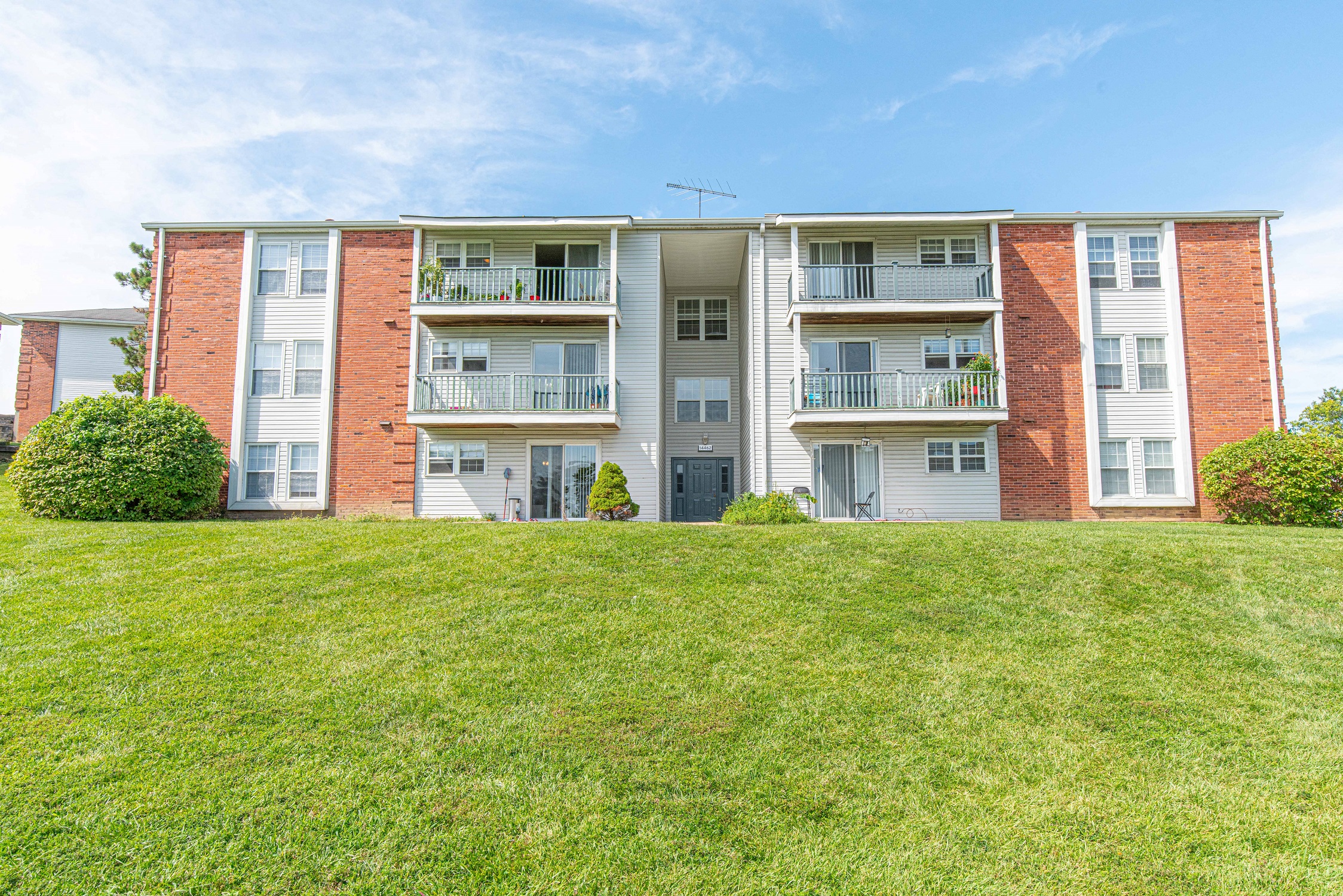 an apartment building on a hill with green grass