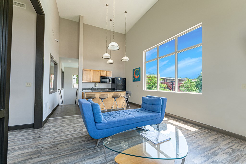 a living room with a blue couch and a kitchen