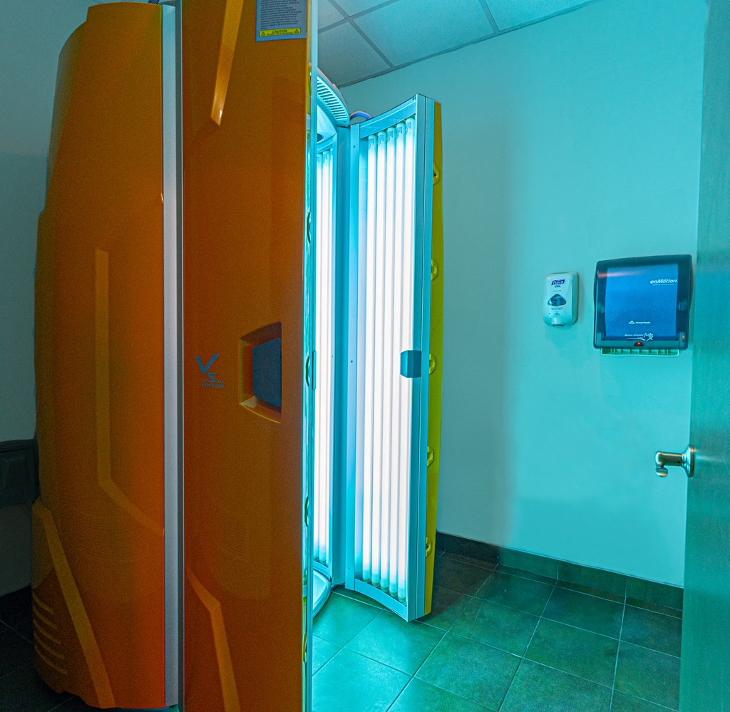 a bathroom with a door and a television on the wall